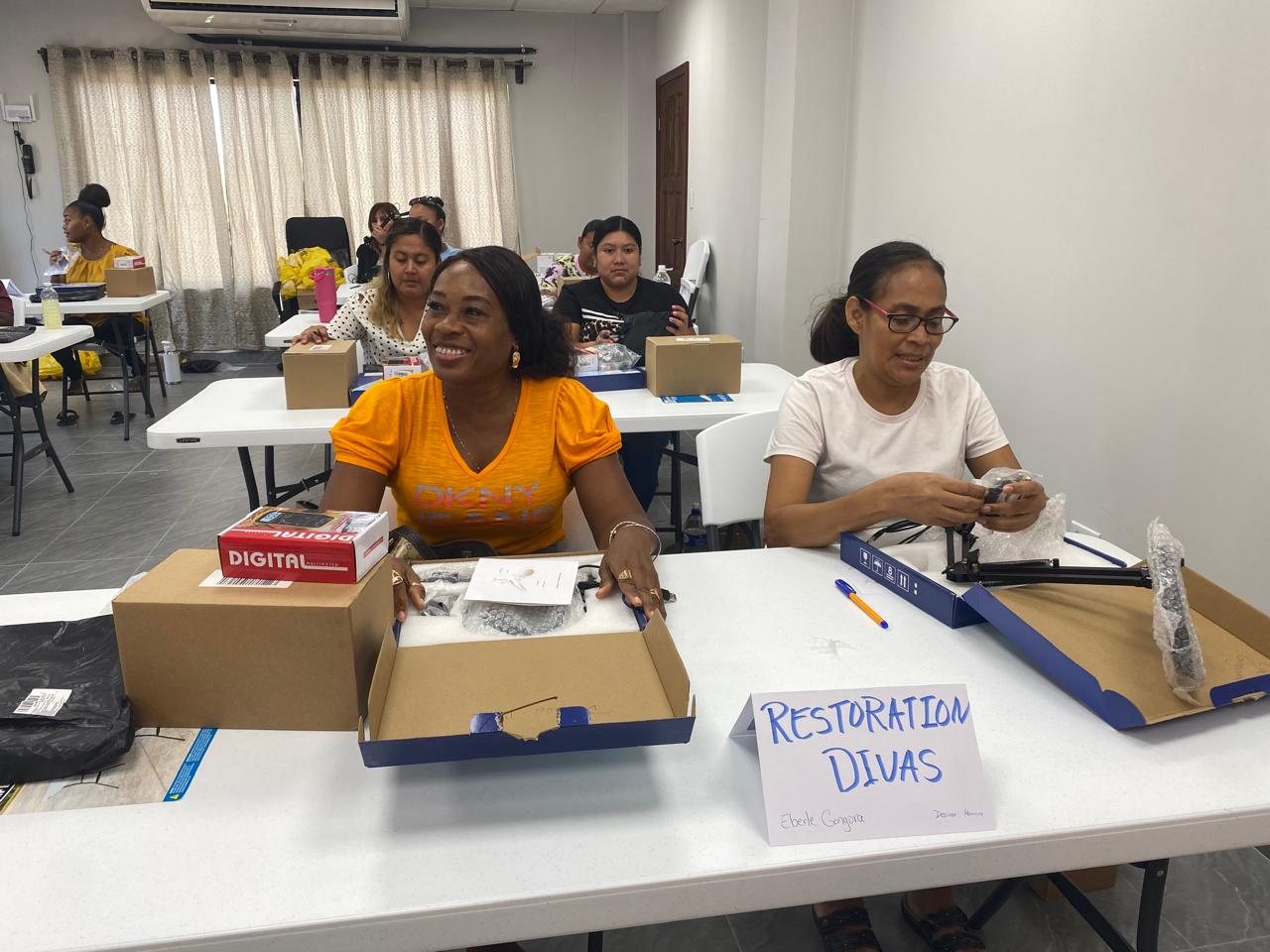 Women unboxing repair kits at a cell phone repair class